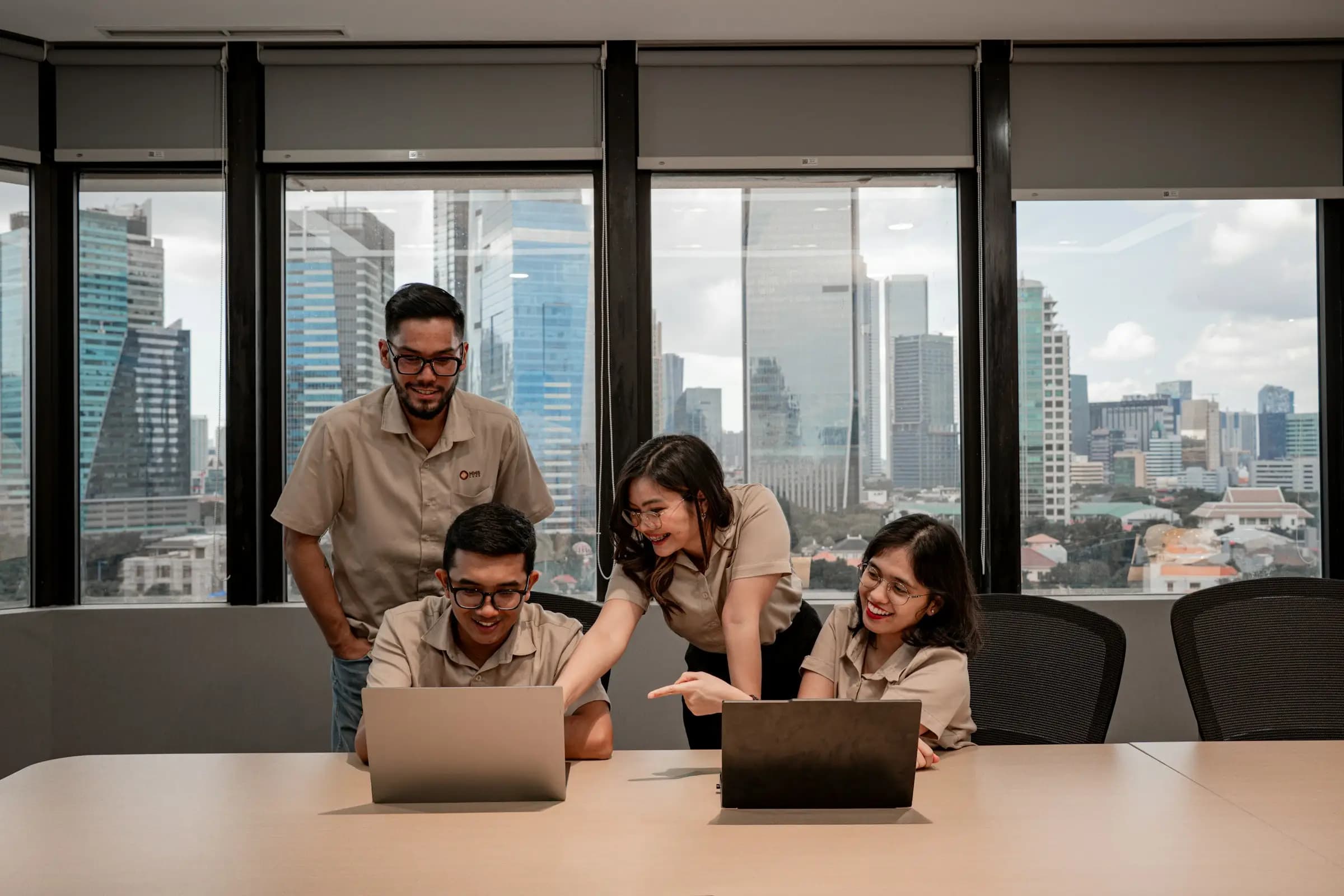 A Talentbes client team collaborating on laptops in a city office